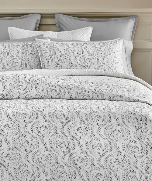 Layered grey and white botanical duvet cover set styled on a bed.