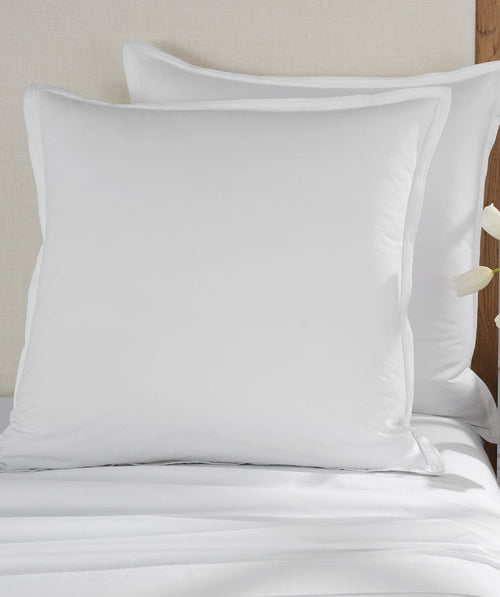 Two white percale euro shams styled on a bed.