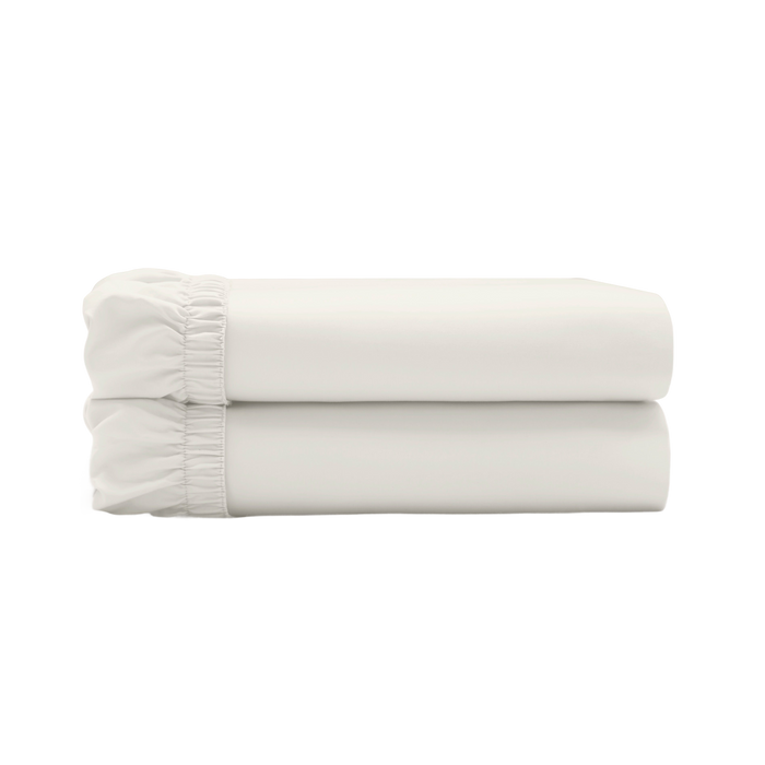 Two ivory fitted sheets folded and stacked.